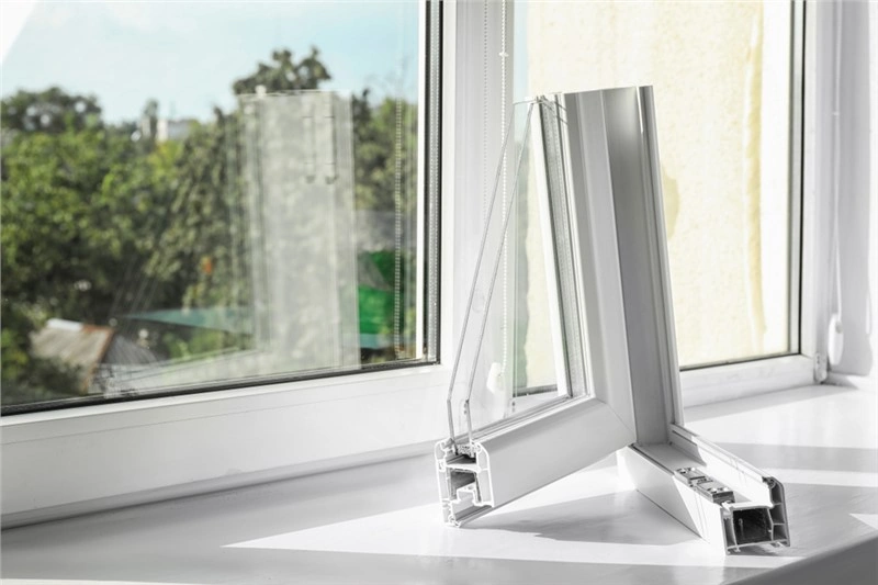 Before buying replacement windows, a white window is sitting on a window sill.