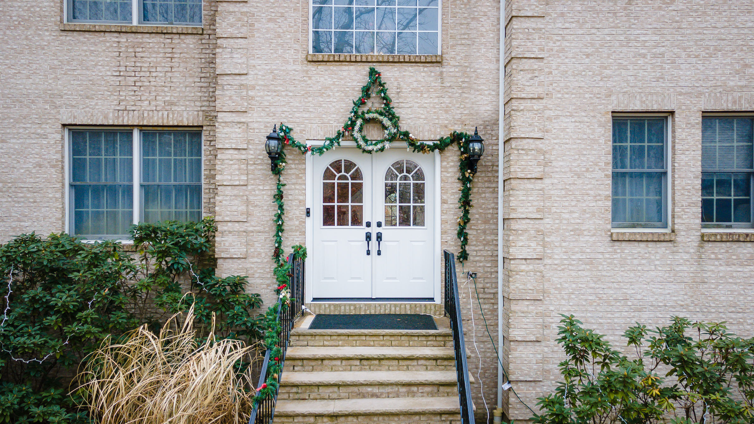 A house with a front door decorated for christmas.