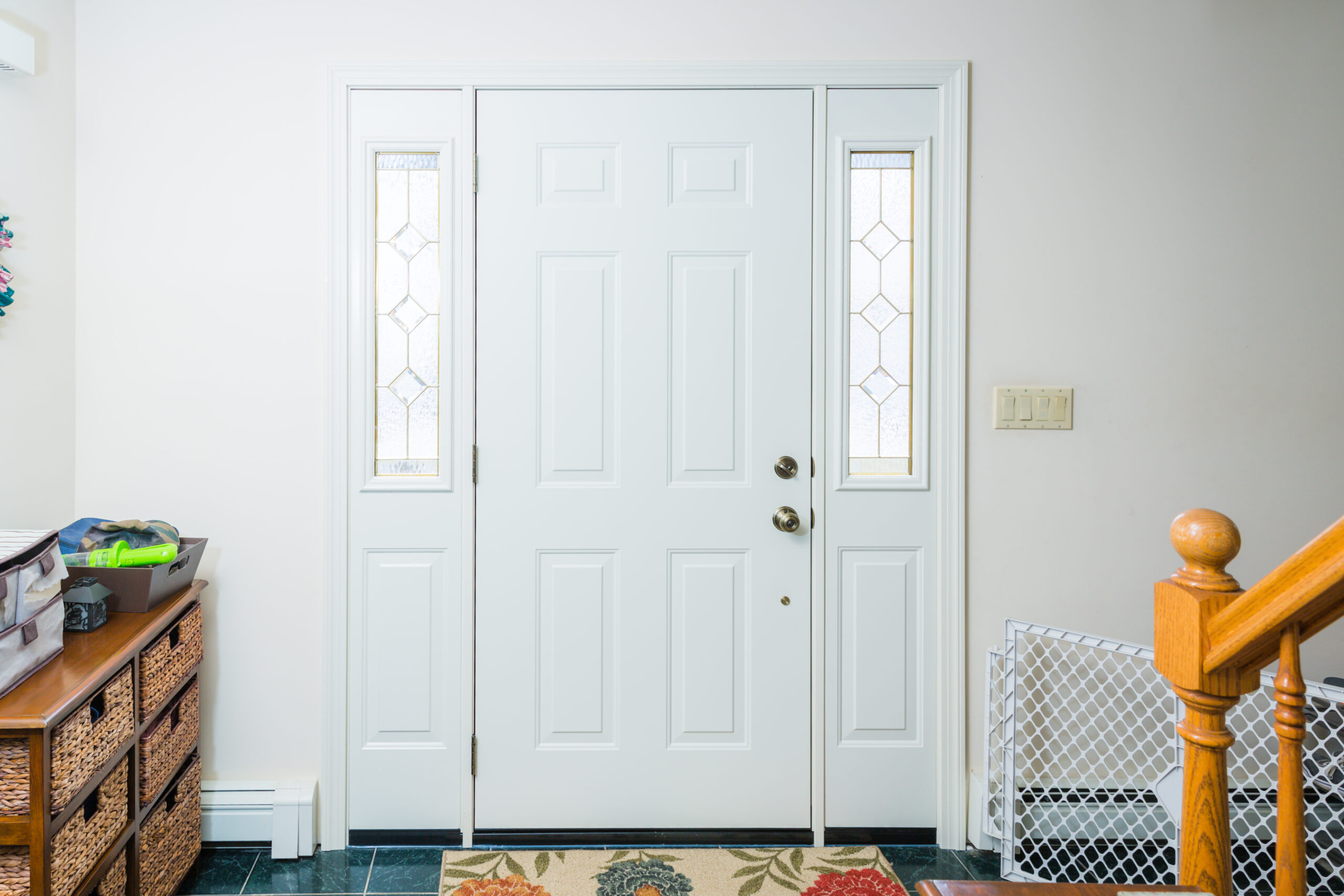 A white door with a rug in front of it.