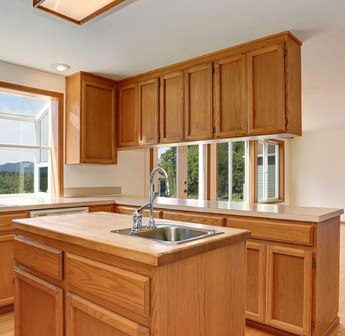 A kitchen with wood cabinets and a sink.