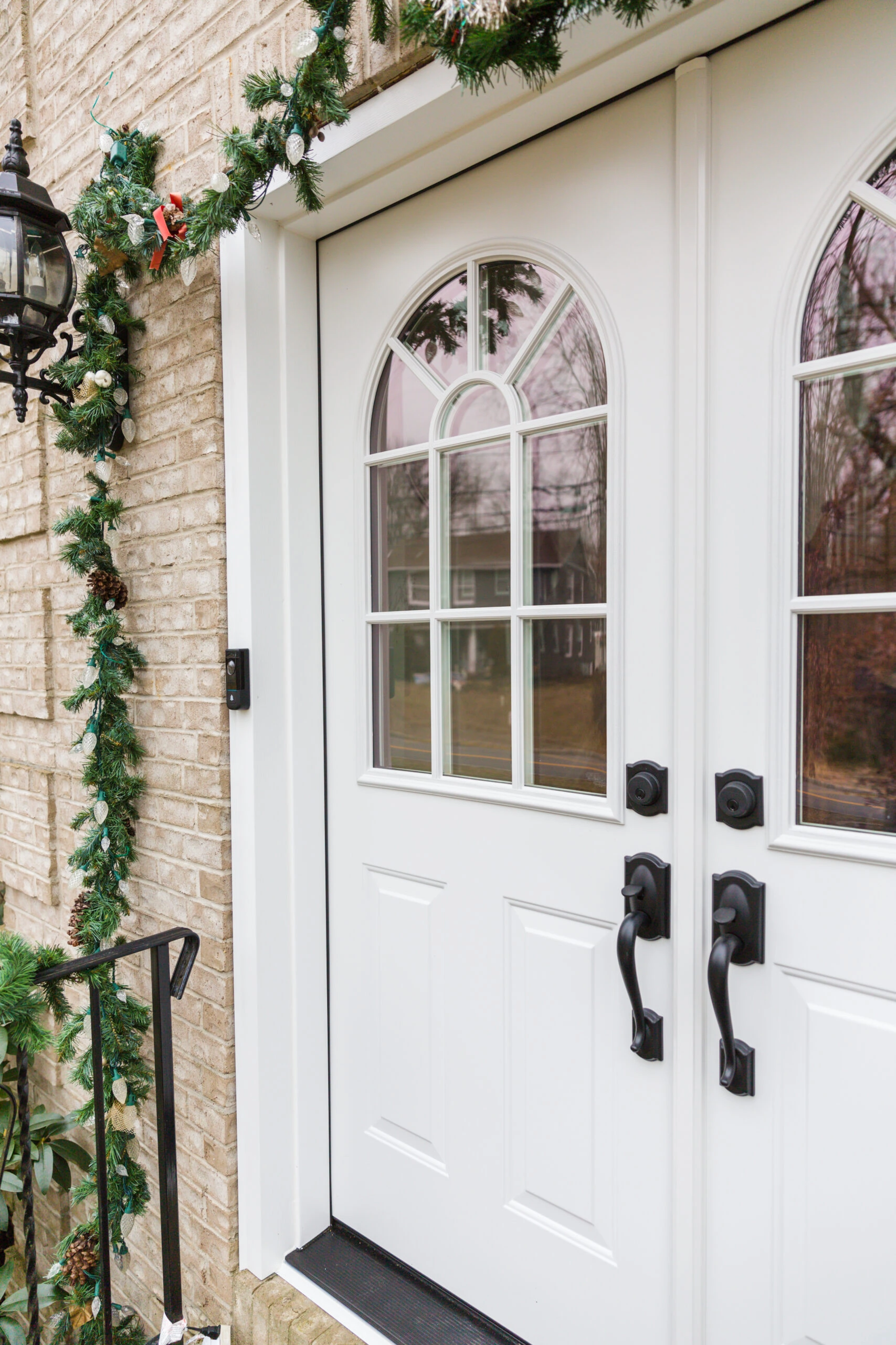 A white front door with garlands on it.