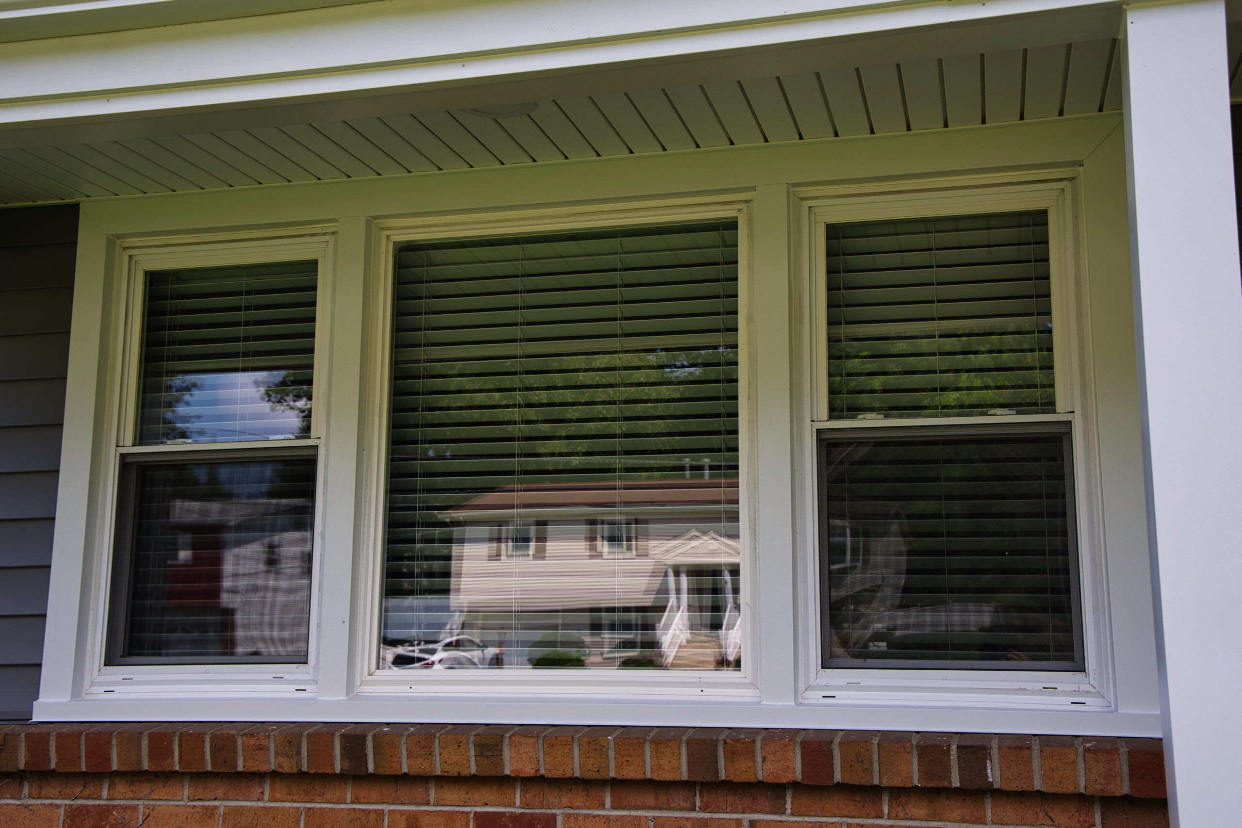 A window with blinds on the side of the house.