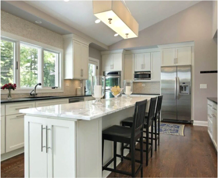 Modern kitchen with stainless steel appliances, white cabinetry, and a central island with seating.