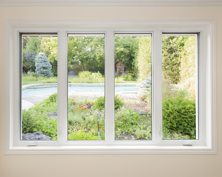 A view of a garden and a pool through a four-paneled window.