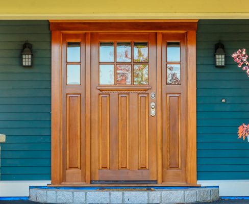 A house with a wooden front door that may require replacement during the best time of year for door replacement.